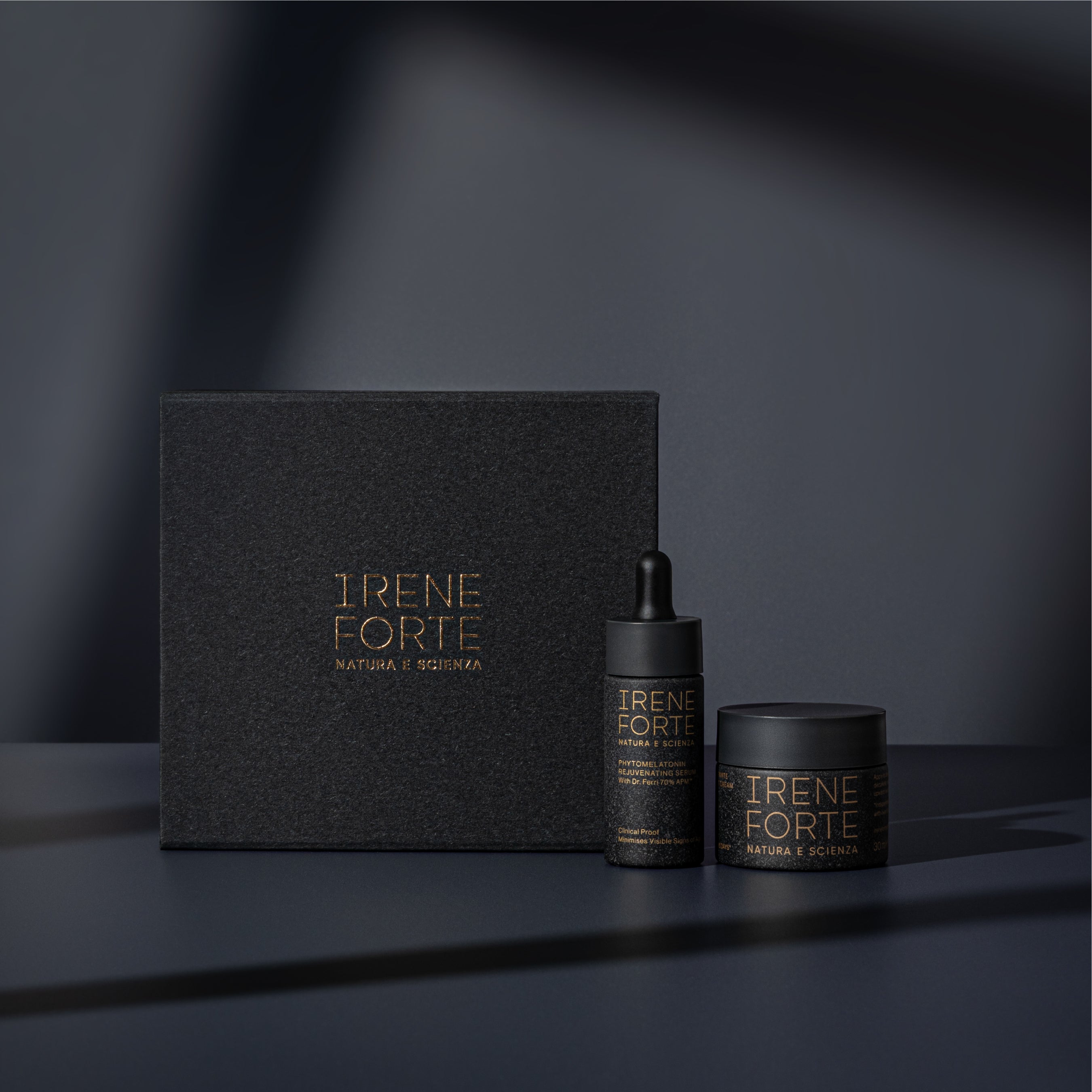 Irene Forte skincare products including a box, dropper bottle, and jar on a dark background