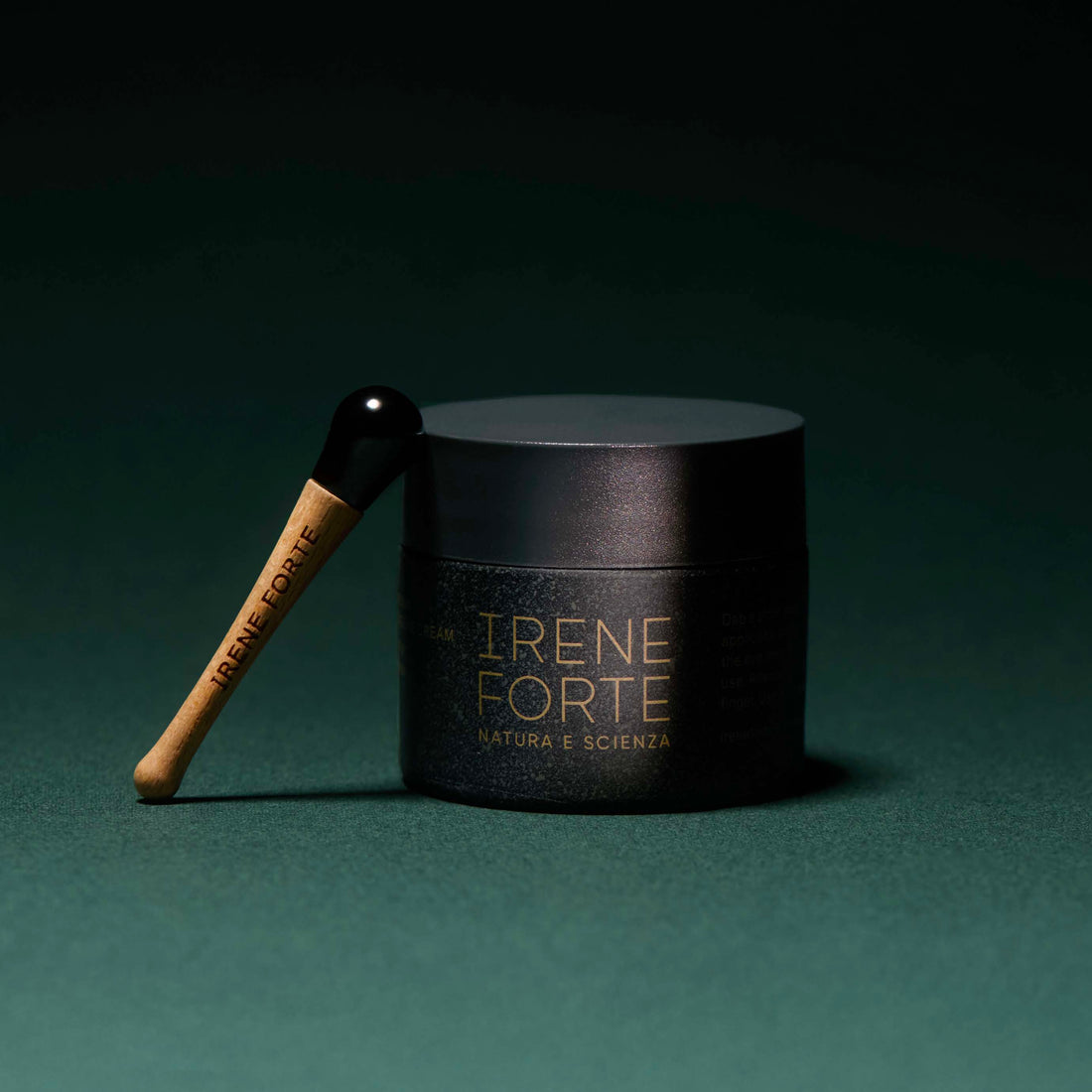 Irene Forte Skincare Phytomelatonin Rejuvenating Eye Cream shown with its black jar, dark green box, and a white eye-shaped cream dollop on a clean white background.