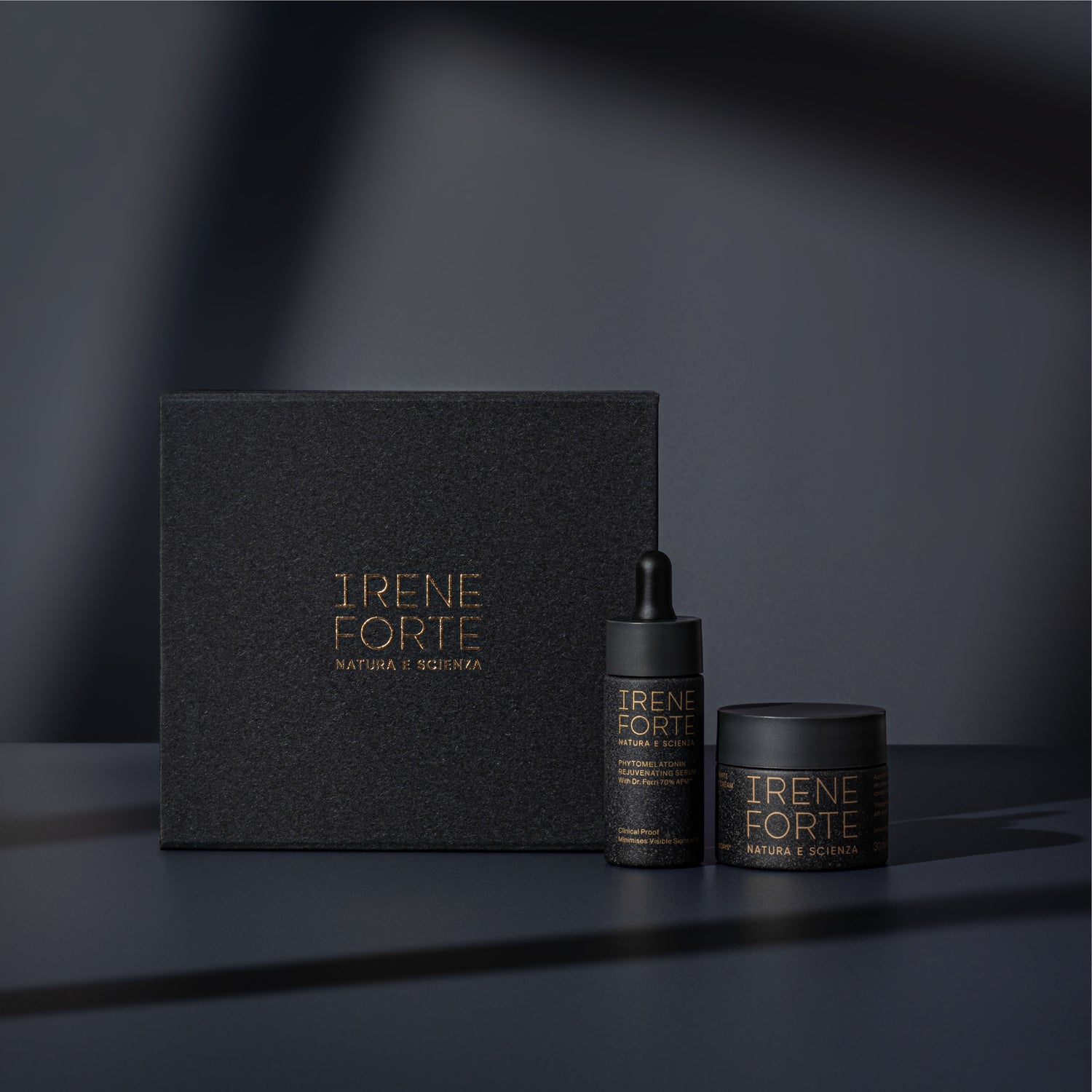 Irene Forte skincare products including a box, dropper bottle, and jar on a dark background